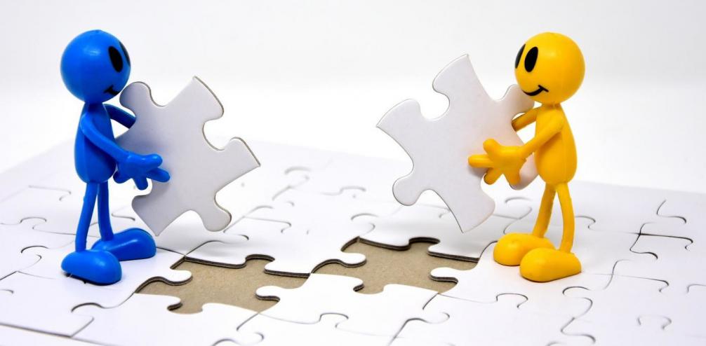 Symbolbild zwei Männchen mit Puzzleteilen